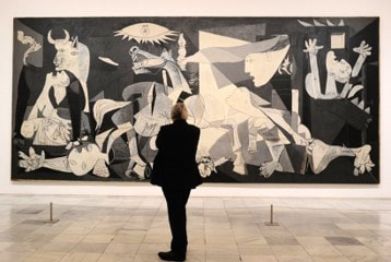 Man standing in front of Guernica 