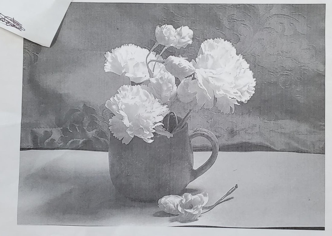 Black and white photo of a mug and flowers. 