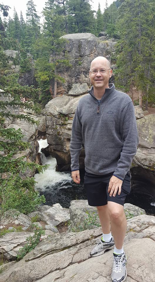 Photo of Bruce Black next to a waterfall