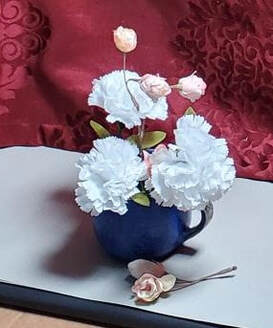 Photograph of a blue mug with flowers and a maroon background. 