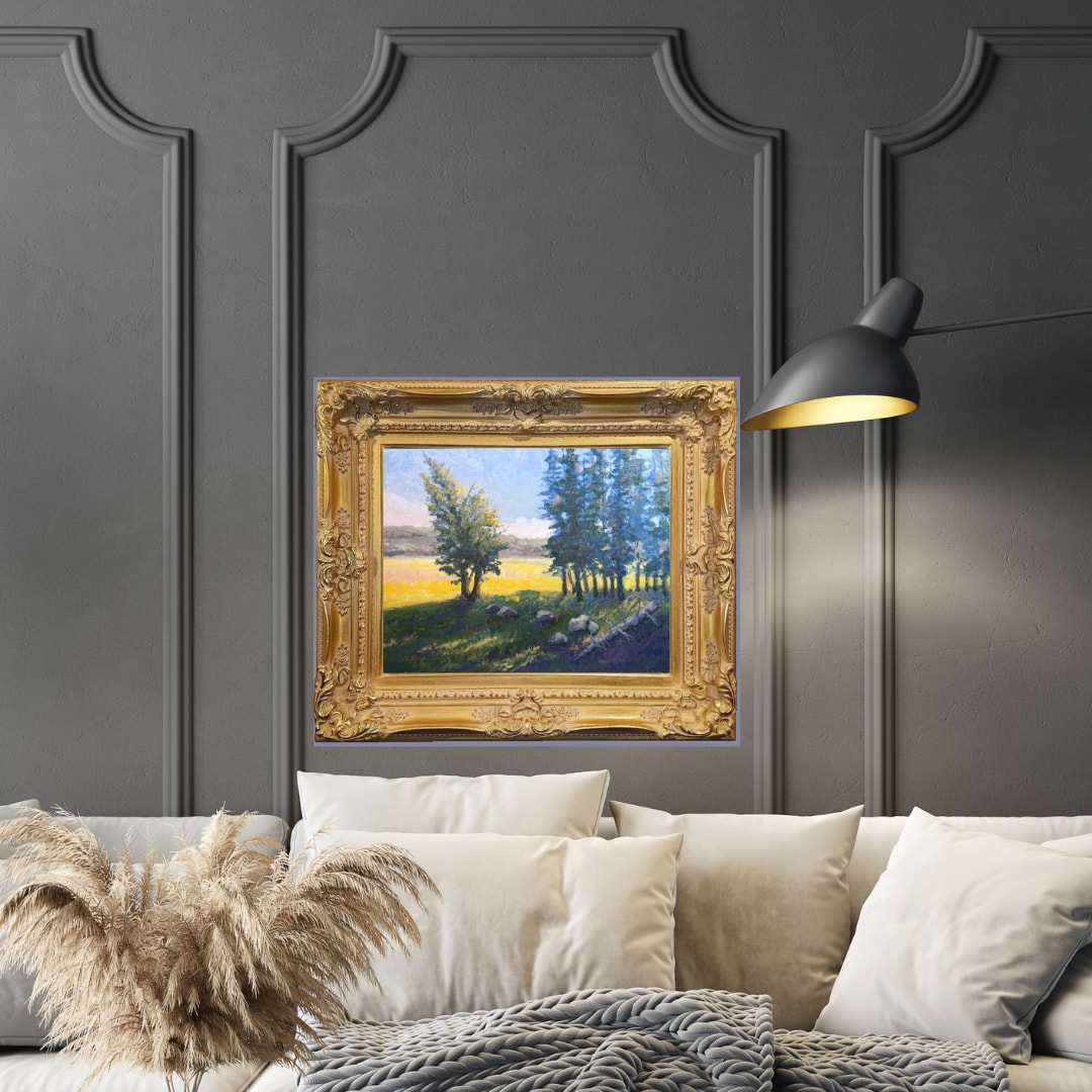 Landscape painting in a gold frame on a living room wall. 